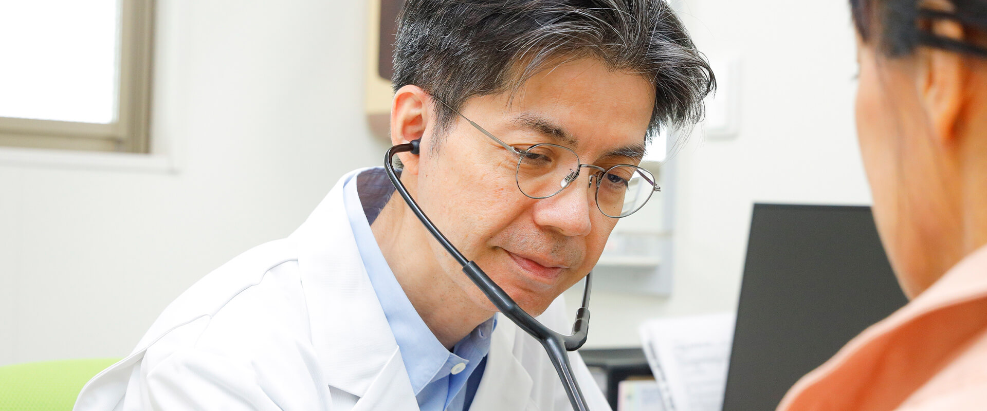 患者に聴診器をあてる医師